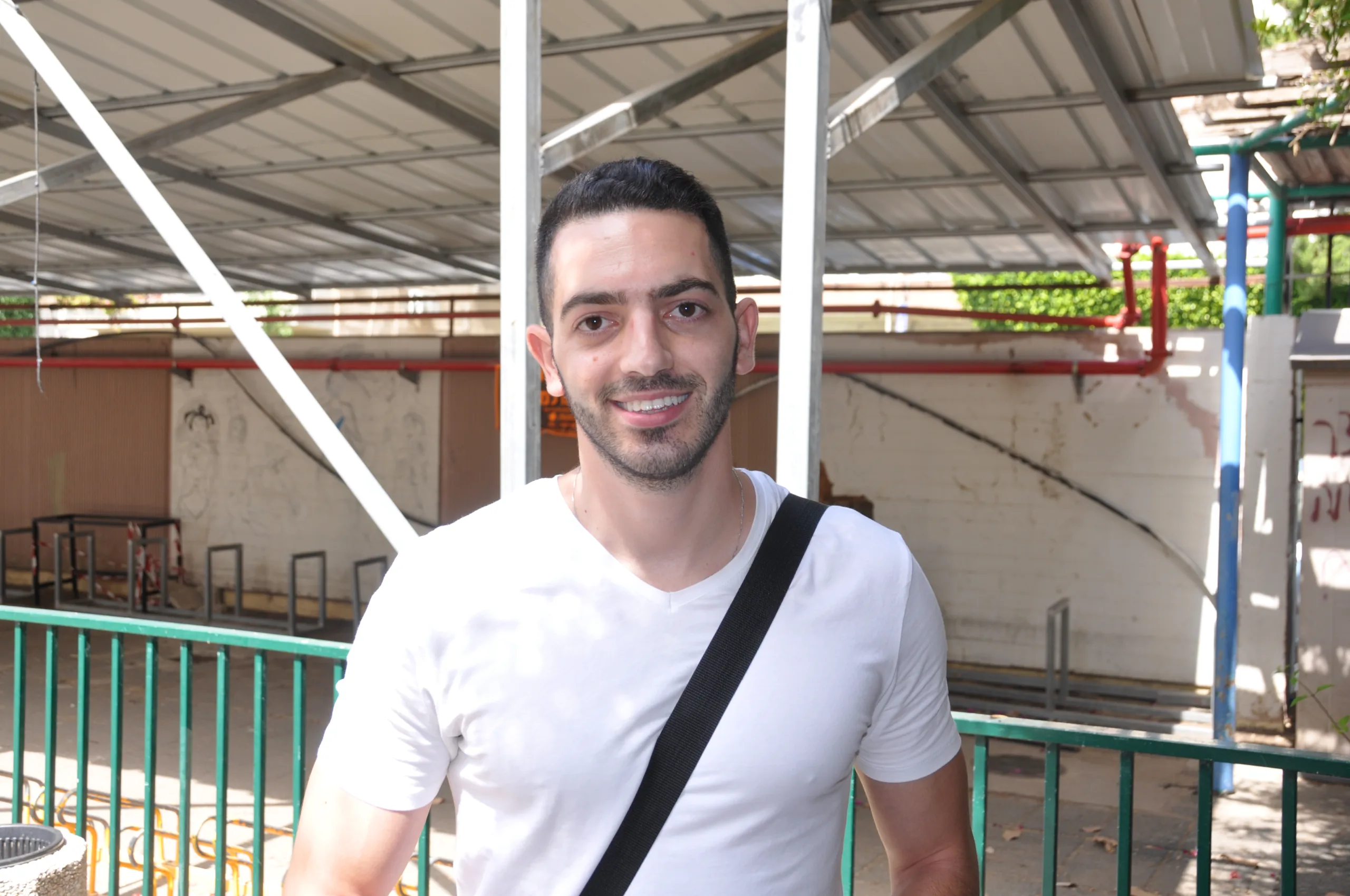 סטודנט מחייך עם תיק לאחר קבלת רישיון פנסיוני במכללת אורין שפלטר