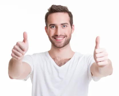 סטודנט מחייך עם שני גודלים למעלה לאחר הצלחה בלימודי גמר פנסיוני במכללת אורין שפלטר
